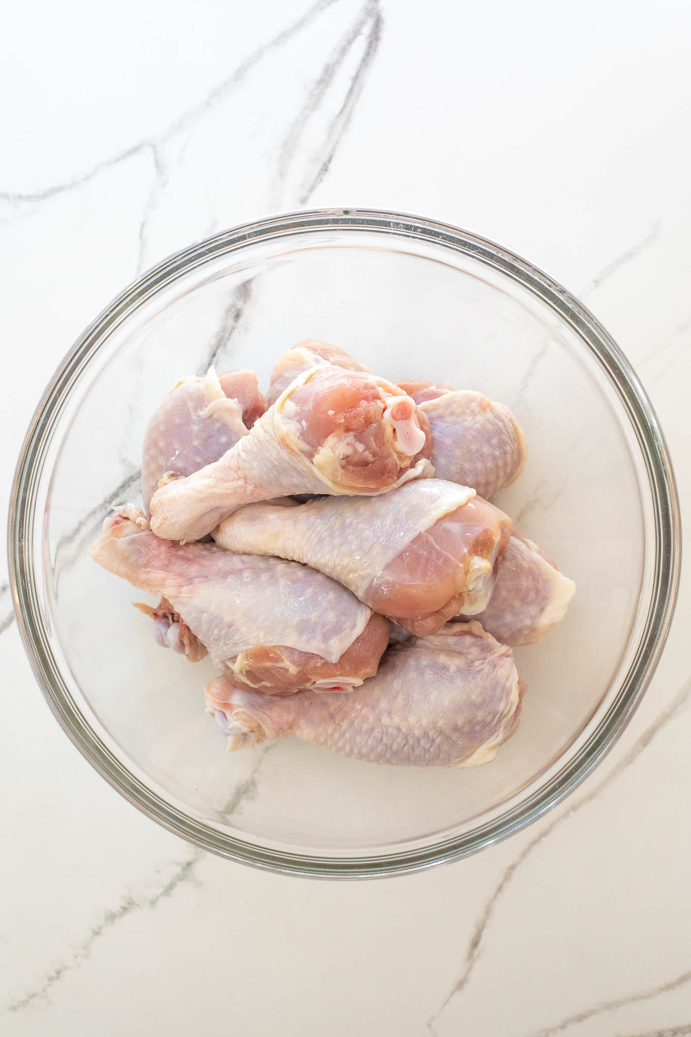 chicken legs in a glass bowl.