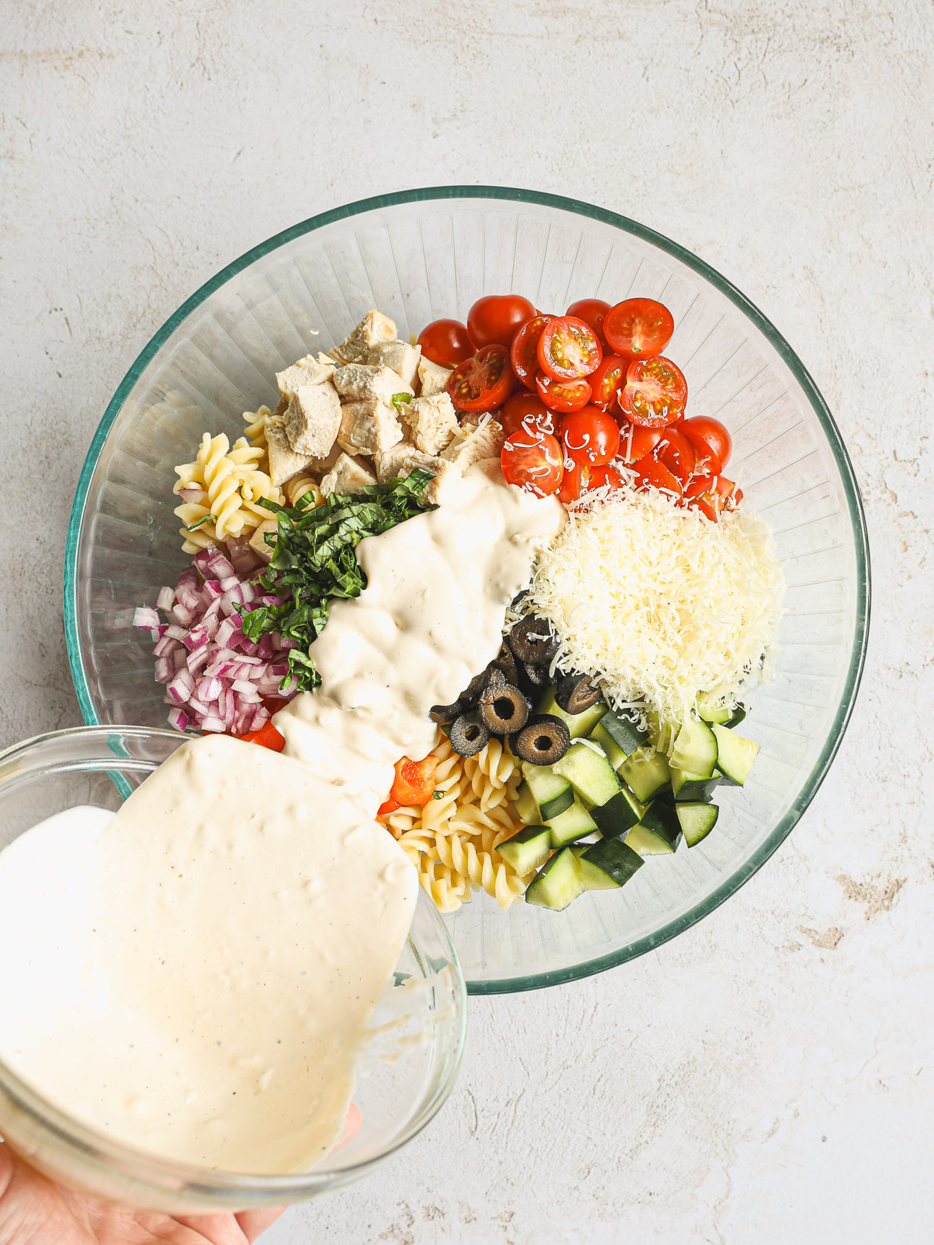 pasta salad covered with dressing in a glass bowl.