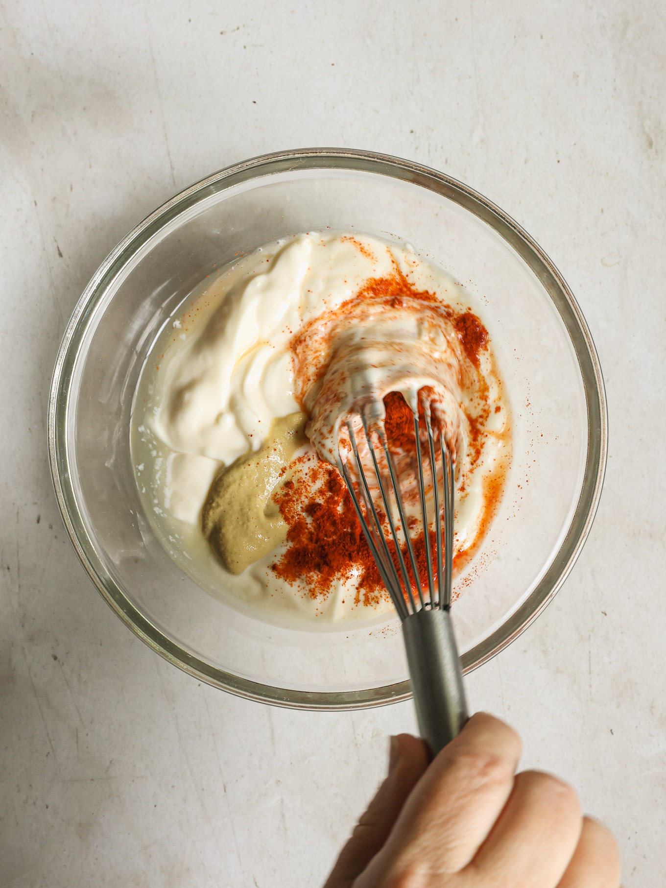 creamy dressing in a bowl with a whisk.