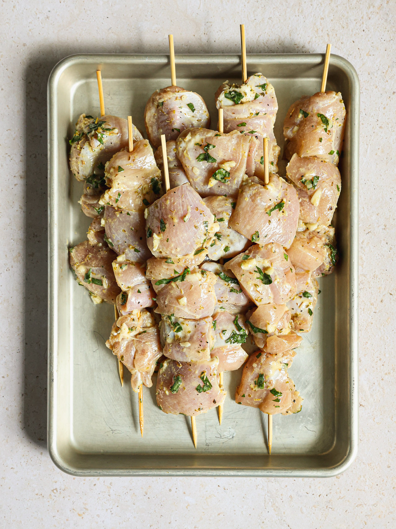 raw chicken skewered onto wooden skewers.