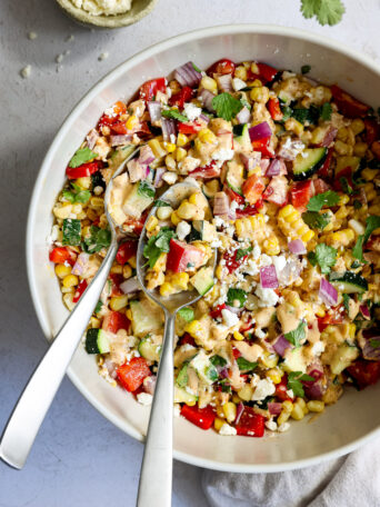 zucchini corn salad in a white bowl.