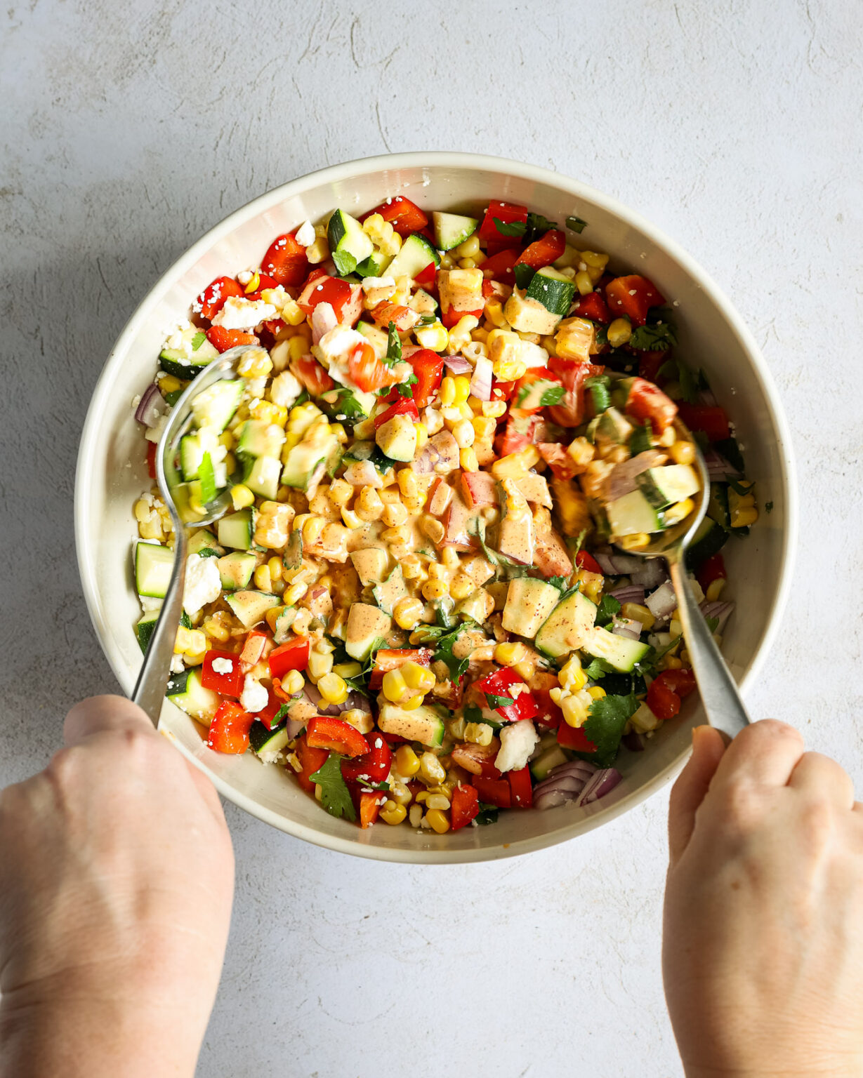 salad being tossed with dressing.