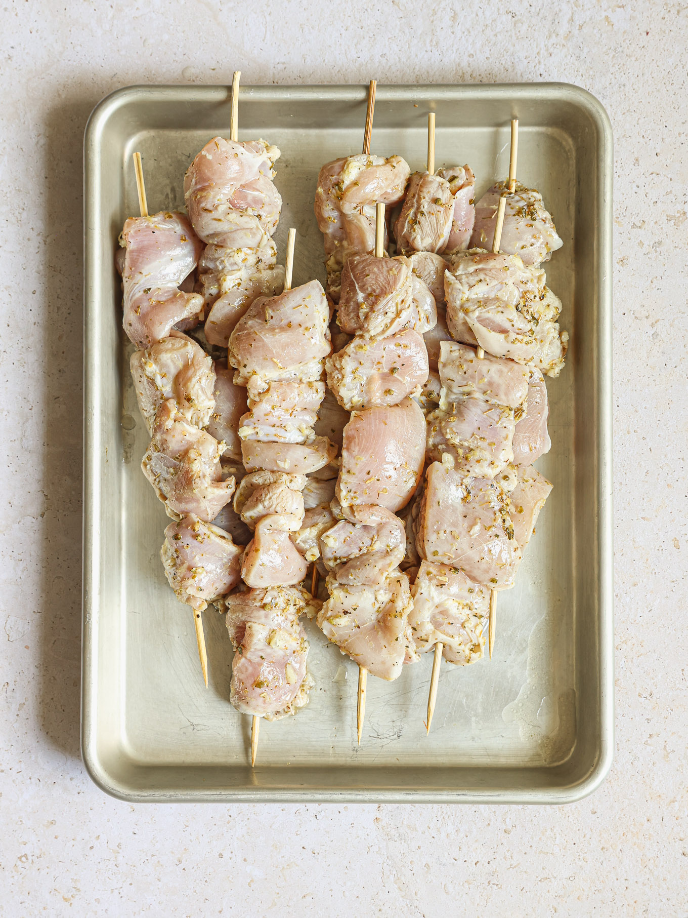 raw chicken on wooden skewers.