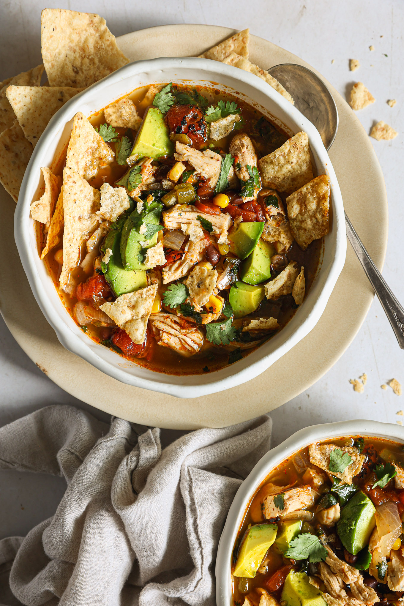 tortilla soup in a bowl topped with cup up avocado.