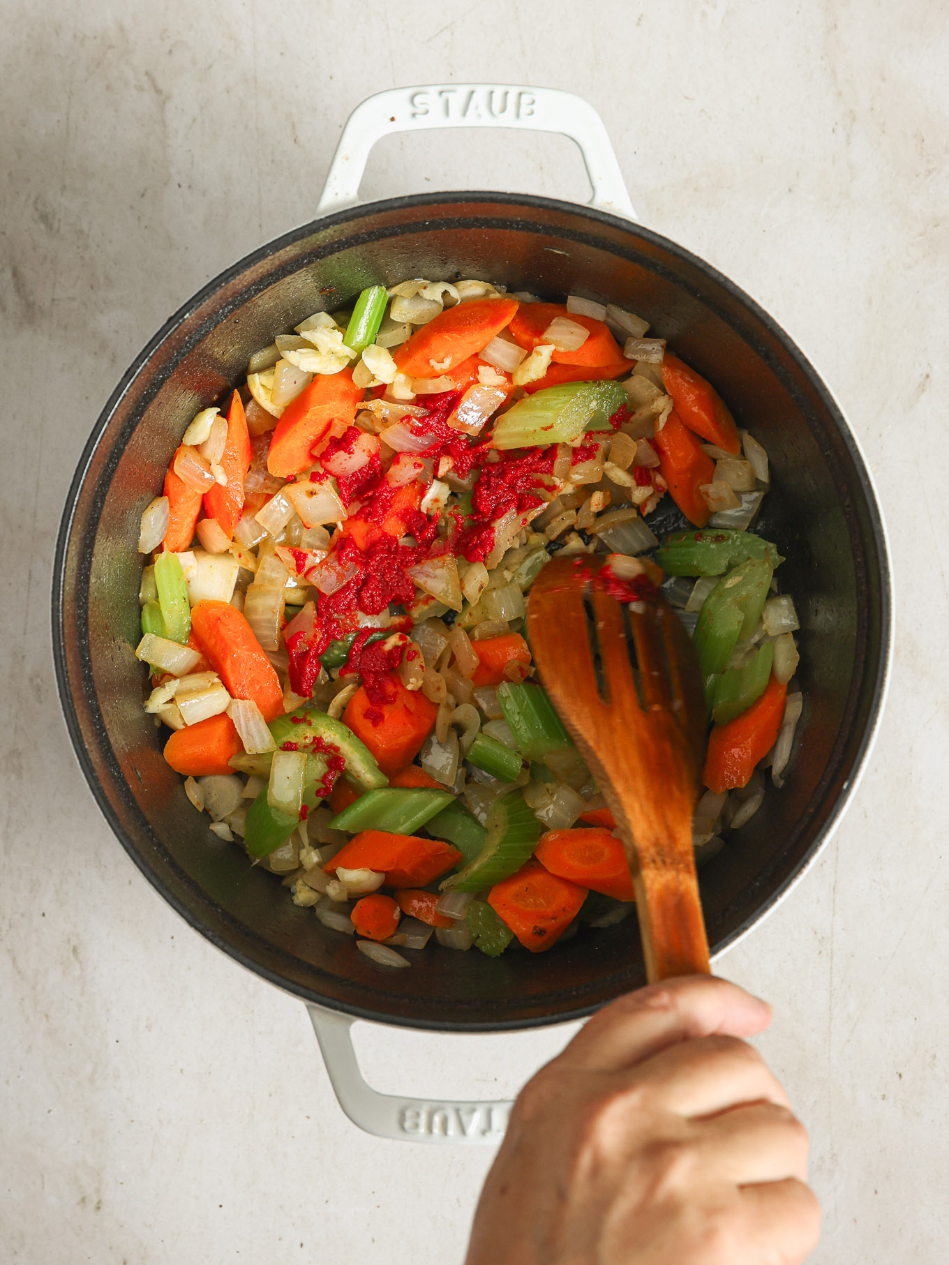 cooked vegetables with tomato paste in a dutch oven.