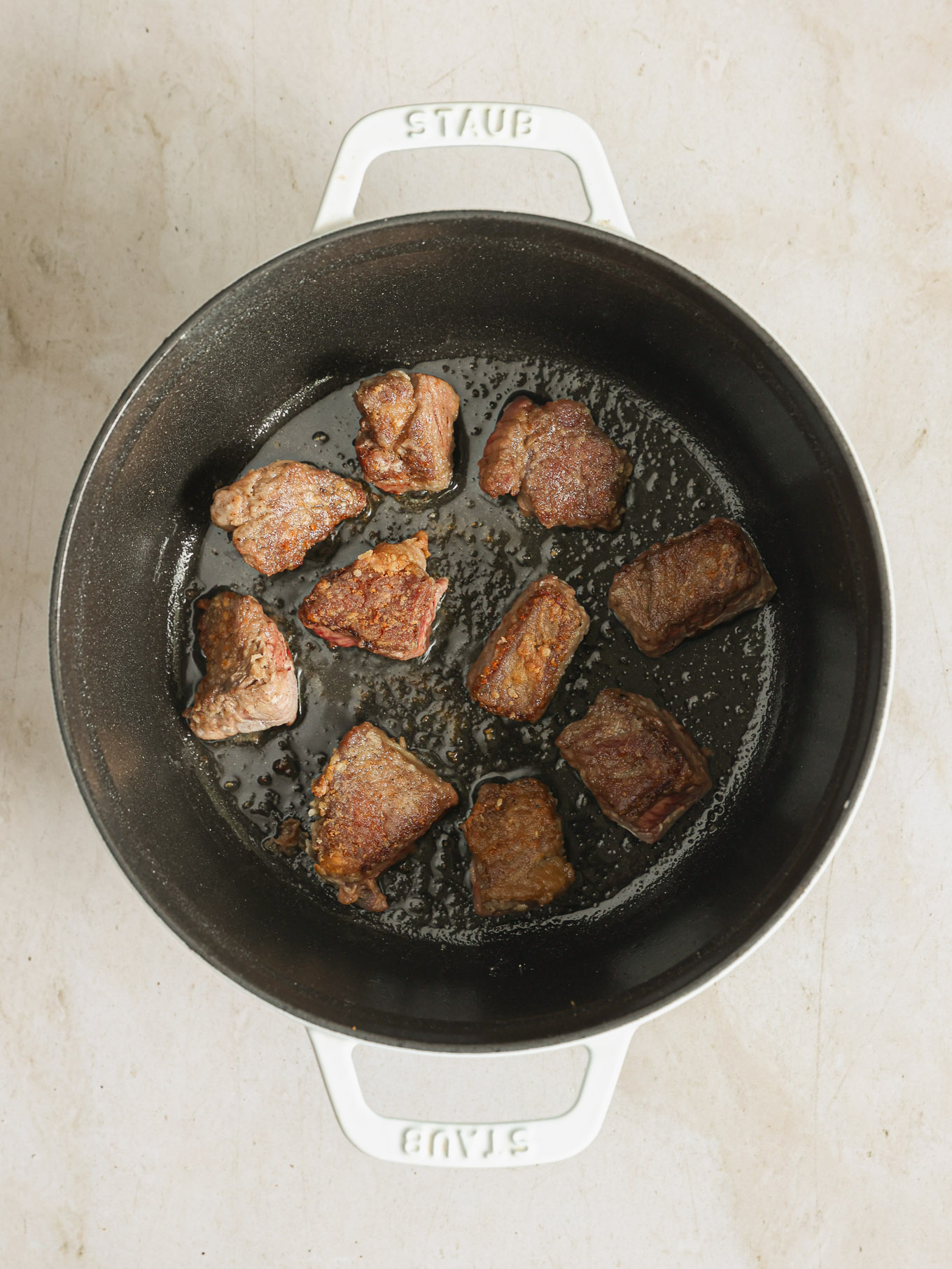 seared beef cubes in a dutch oven.
