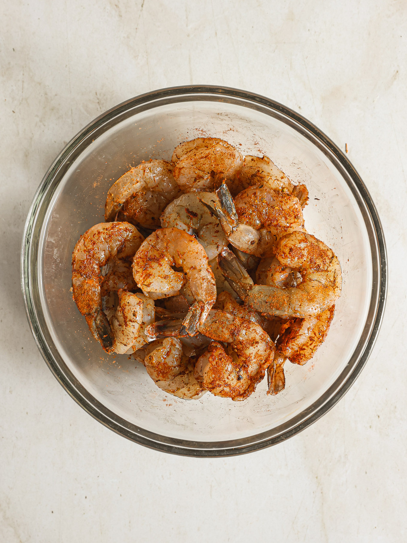 tossed shrimp with cajun spices in a glass bowl.