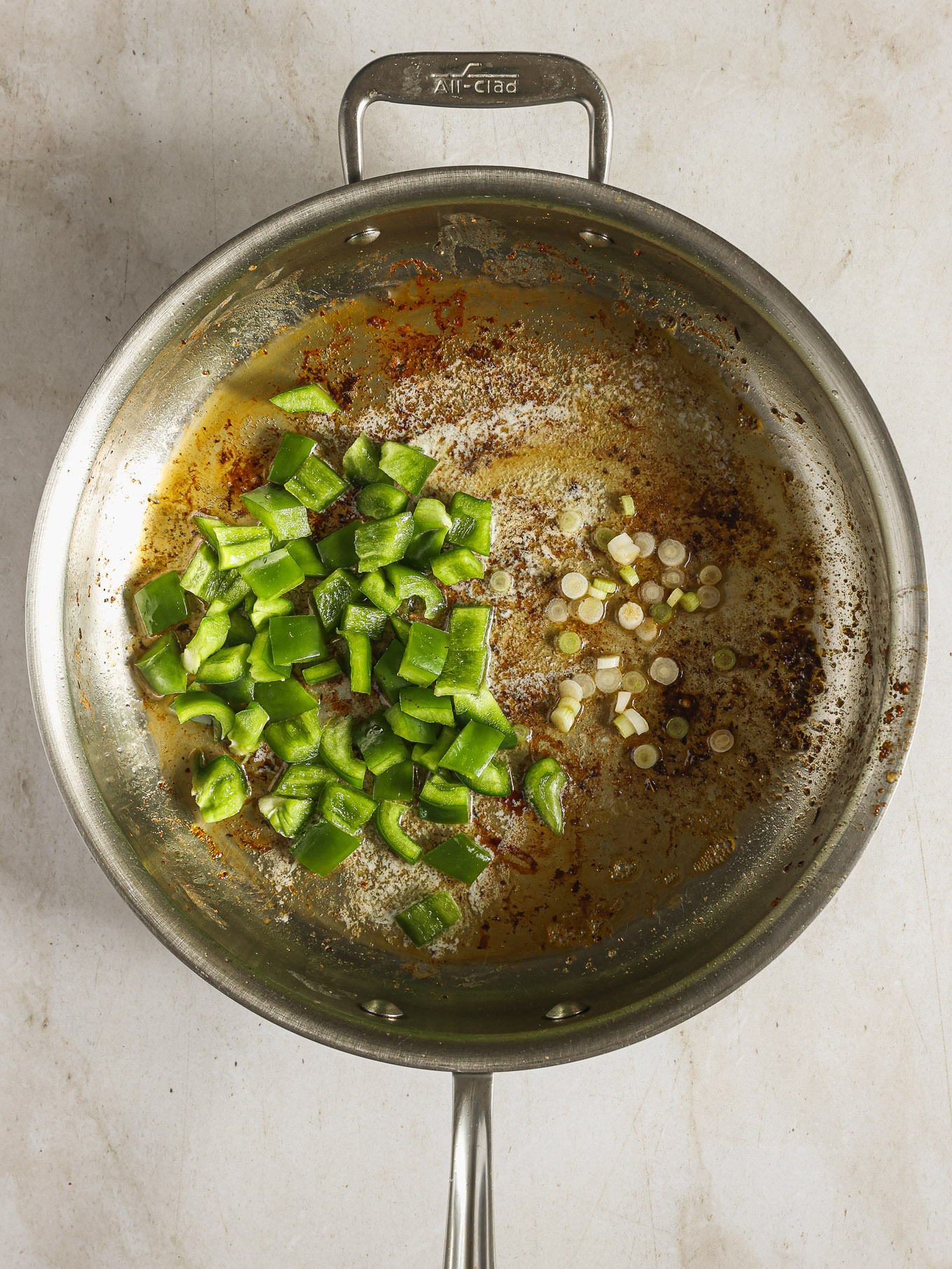 green peppers and garlic in a skillet with oil.