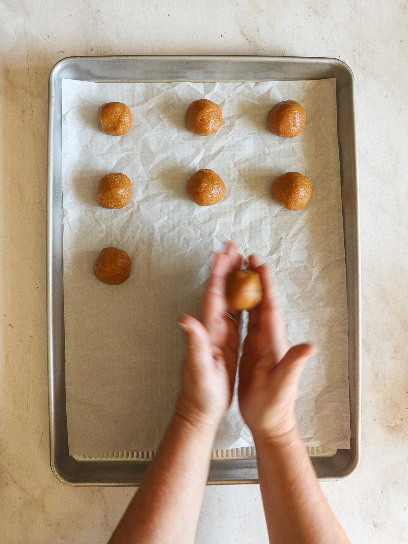rolled cookie dough balls in a baking sheet.