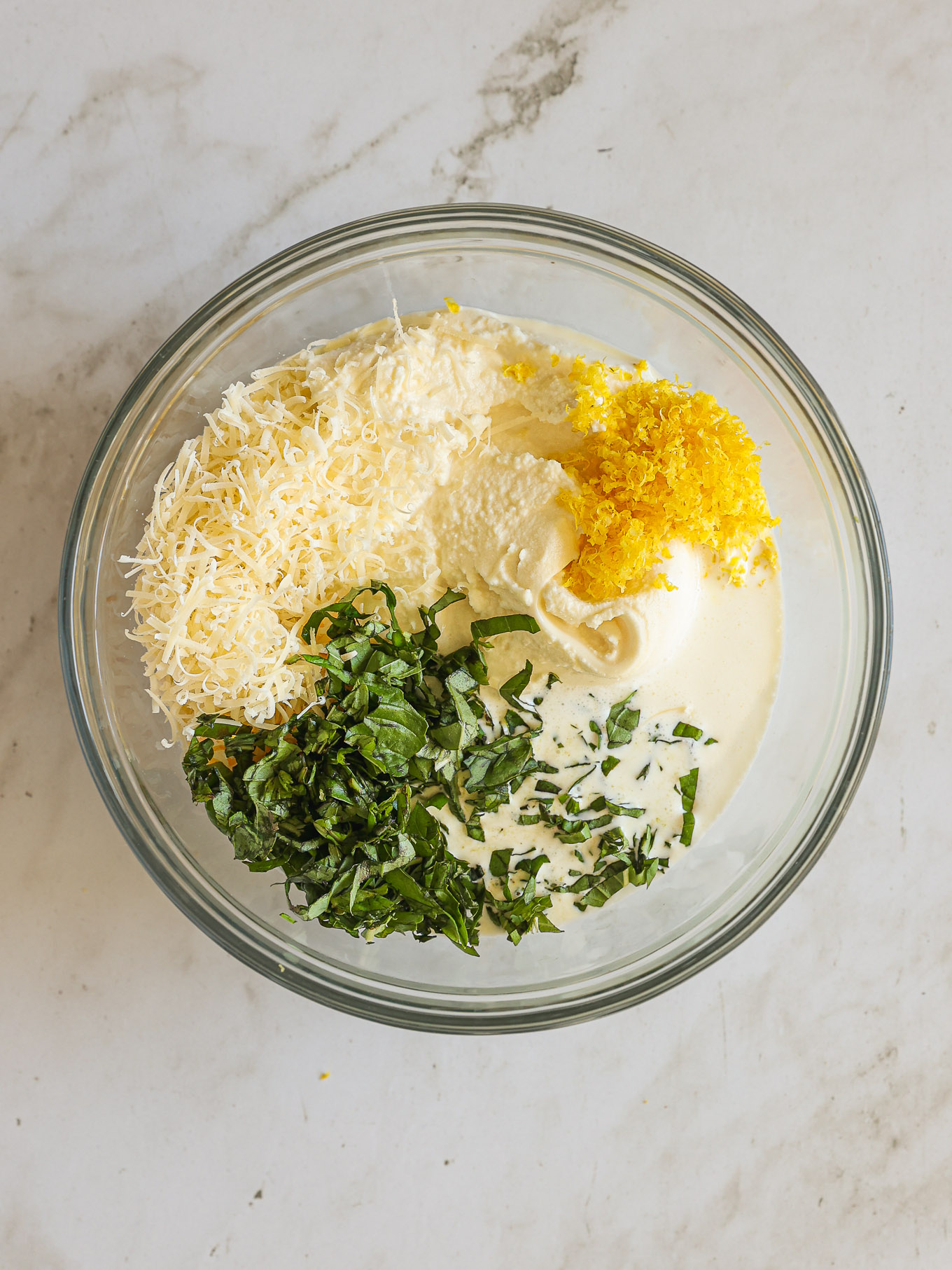 ricotta with cheese and basil in a glass bowl.