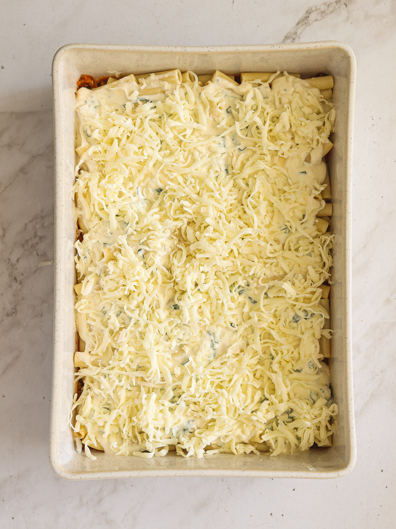 shredded cheese over ricotta and ziti.