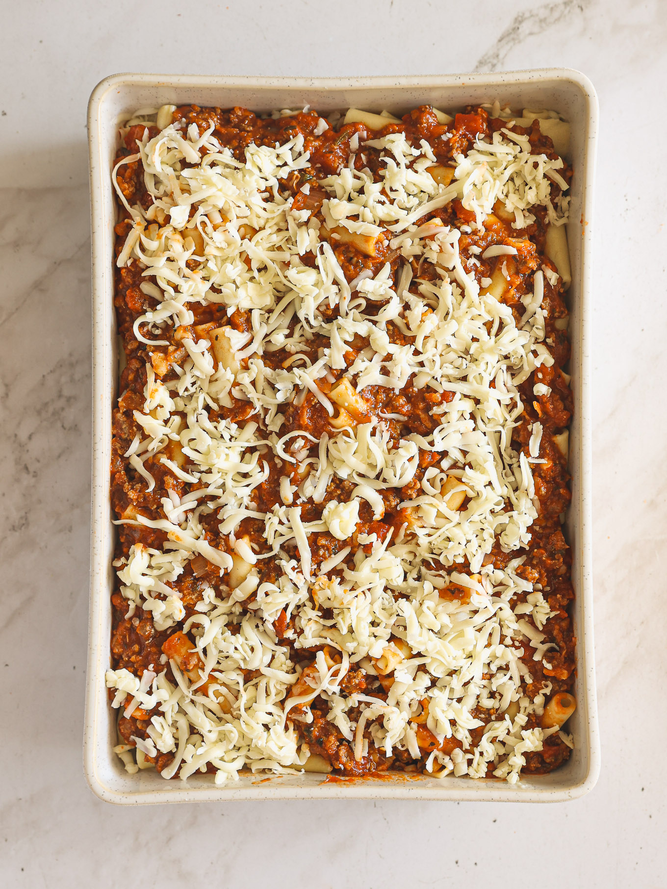 layered ziti pasta in casserole dish.