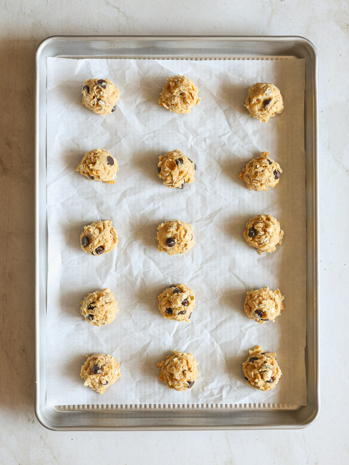 raw cookie dough balls on a baking sheet.