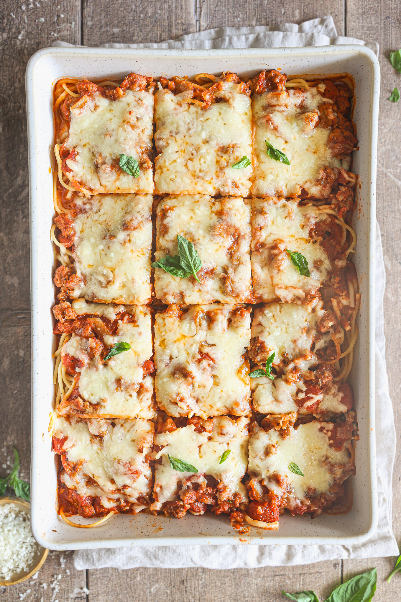 baked spaghetti in a dish cut into squares.