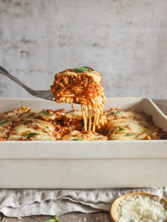 baked spaghetti in a white casserole dish.