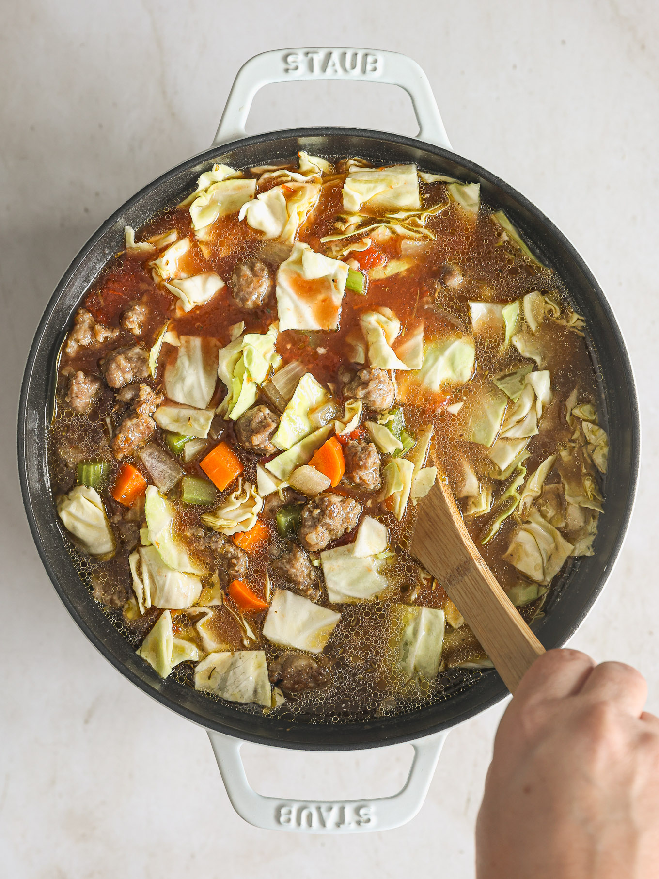 cabbage soup stirred with a wooden spoon.