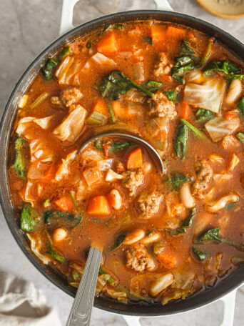 cabbage soup with ladle in a soup pot.