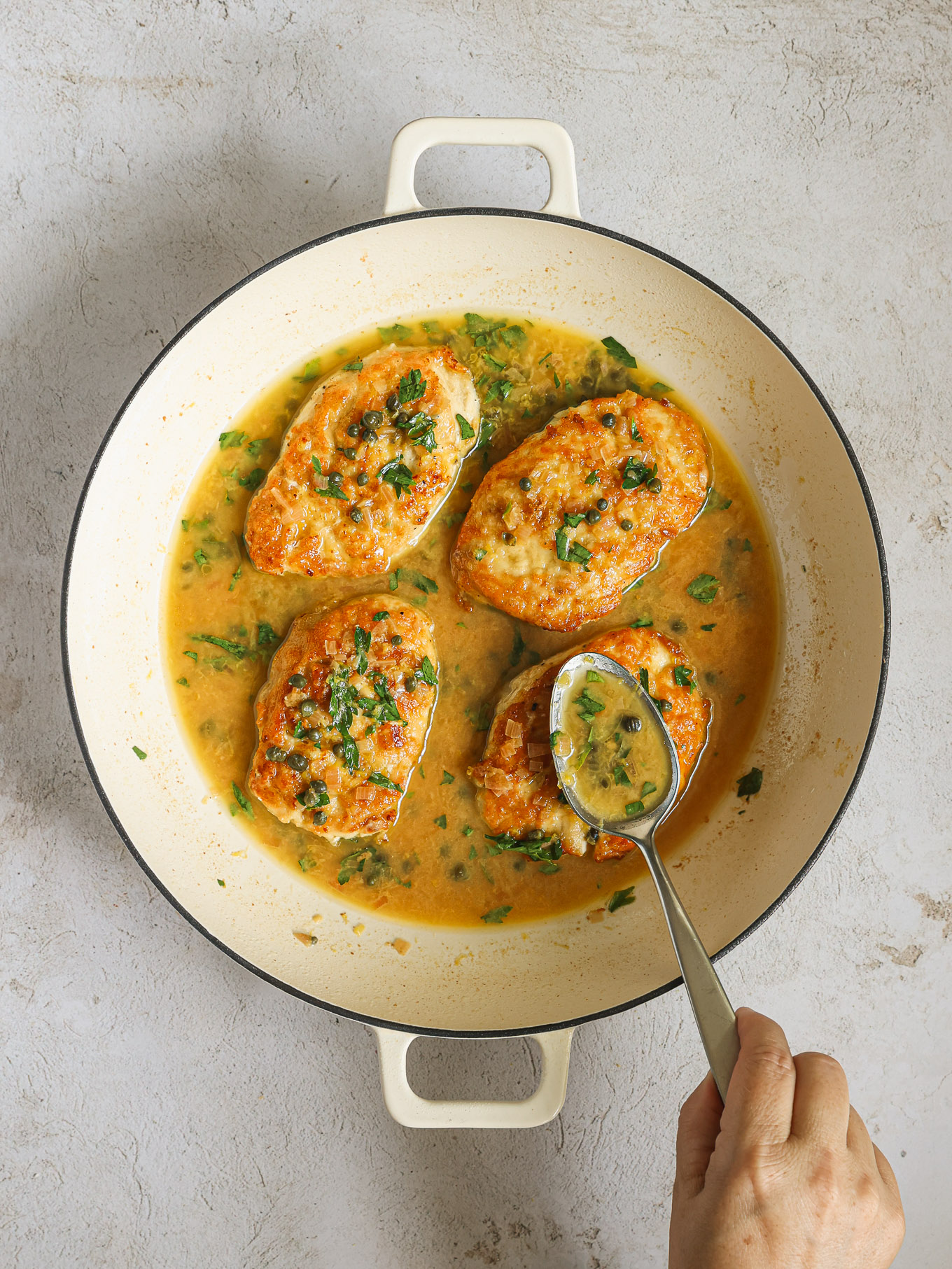 lemon caper sauce spooned over chicken.