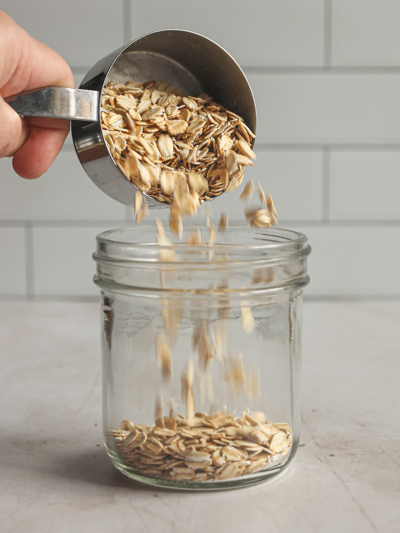 dry oats going into a jar.