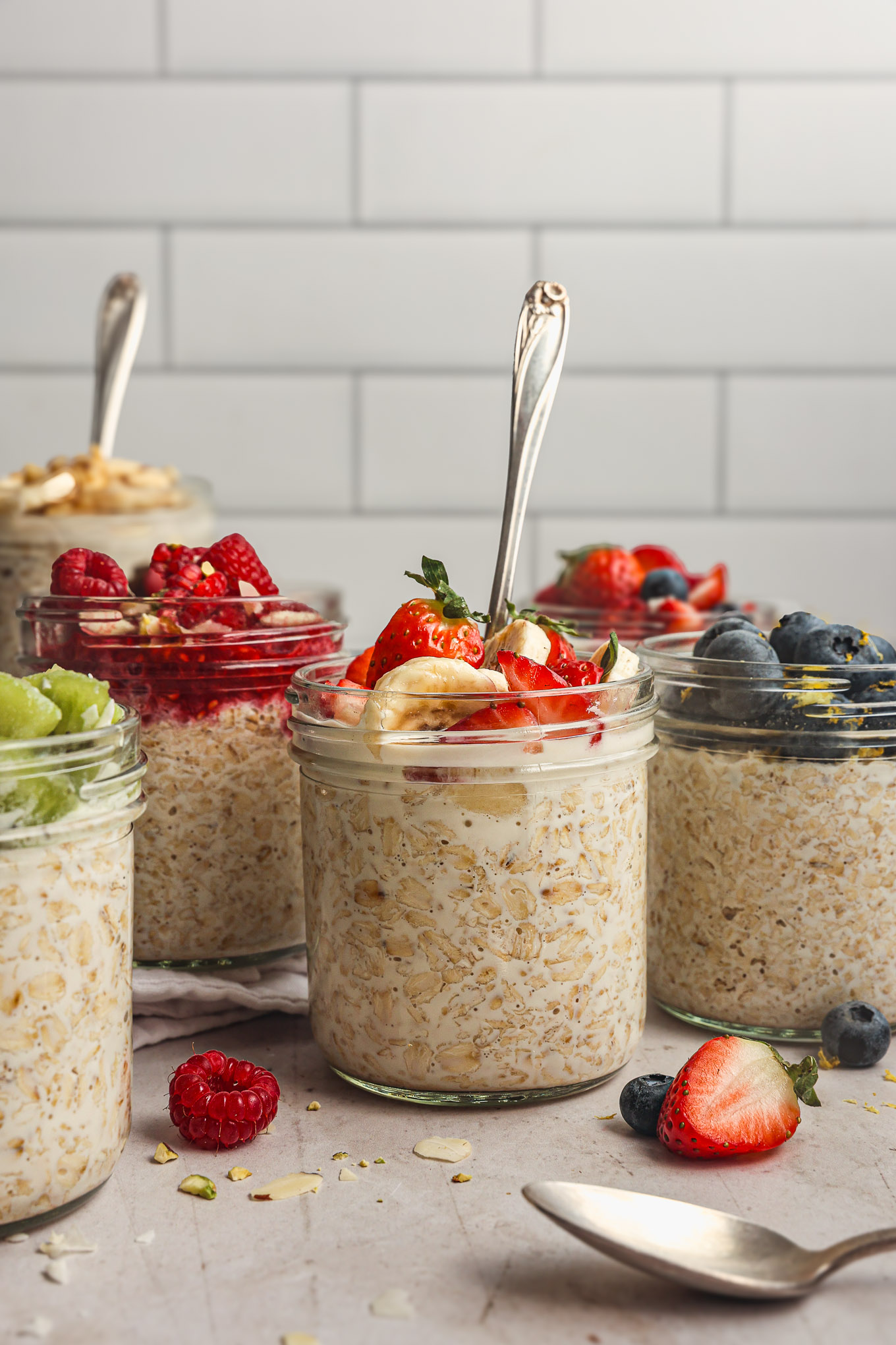 prepared overnight oats topped with fruit in glass jars.