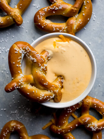 pretzel dunked into cheese sauce.