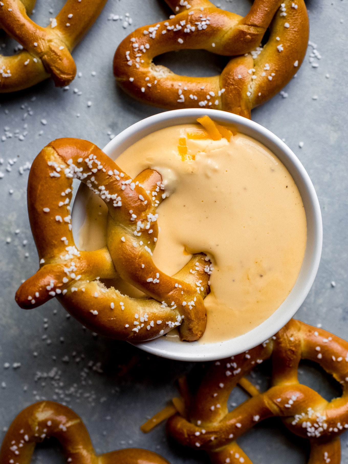pretzel dunked into cheese sauce.