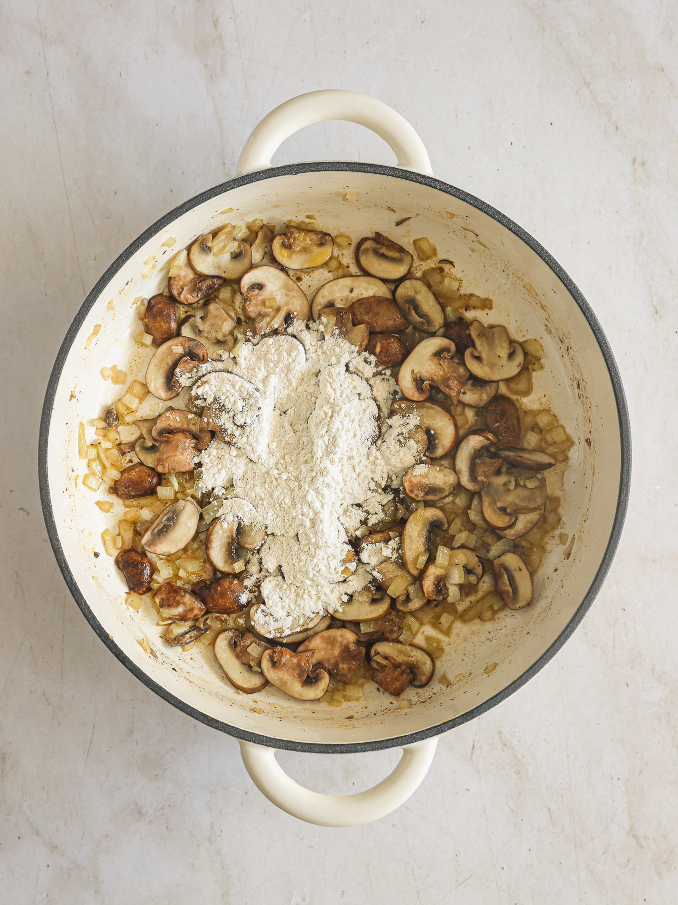 mushrooms with flour in a skillet.