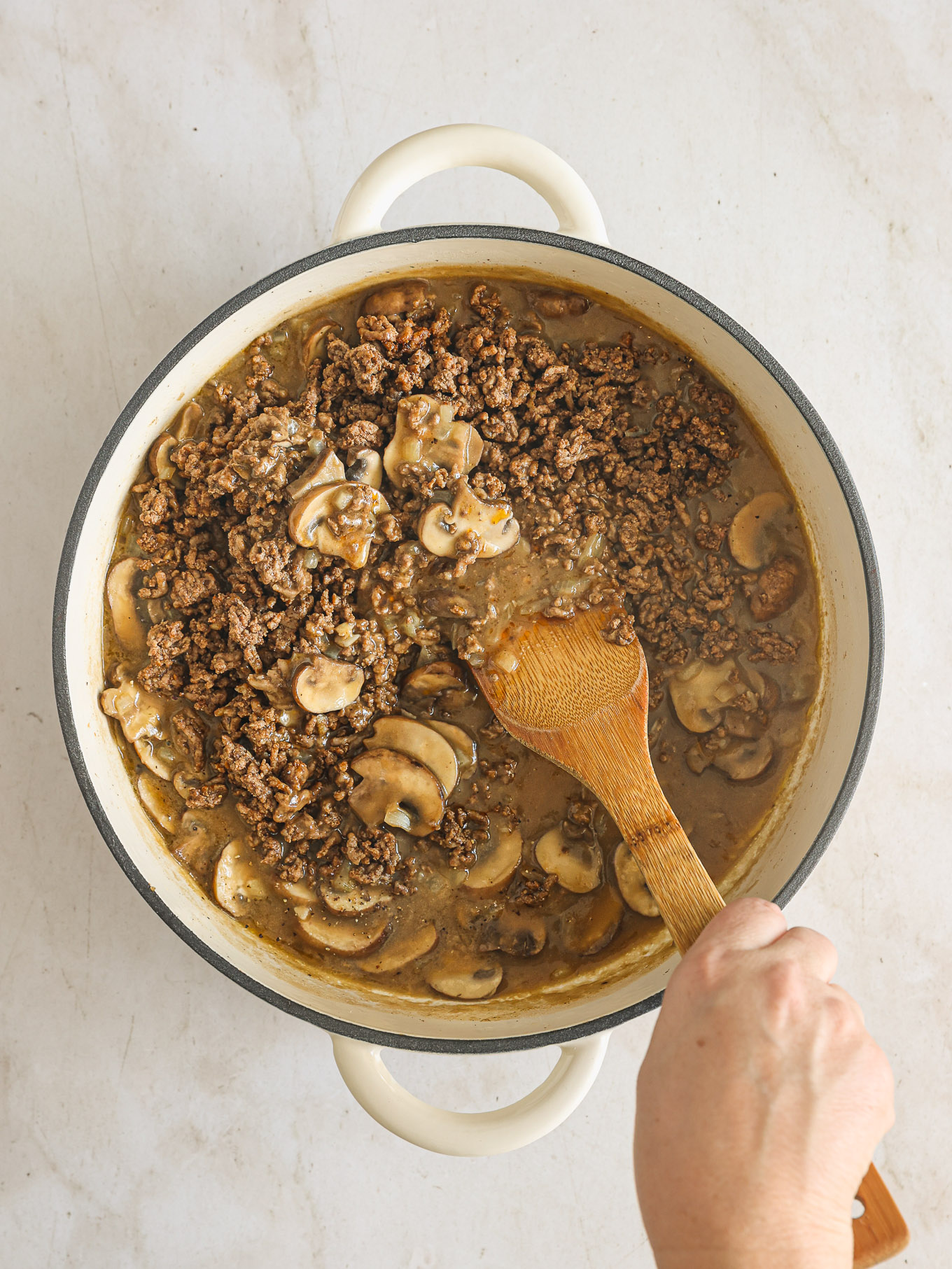 cooked ground beef and mushrooms in a skillet.