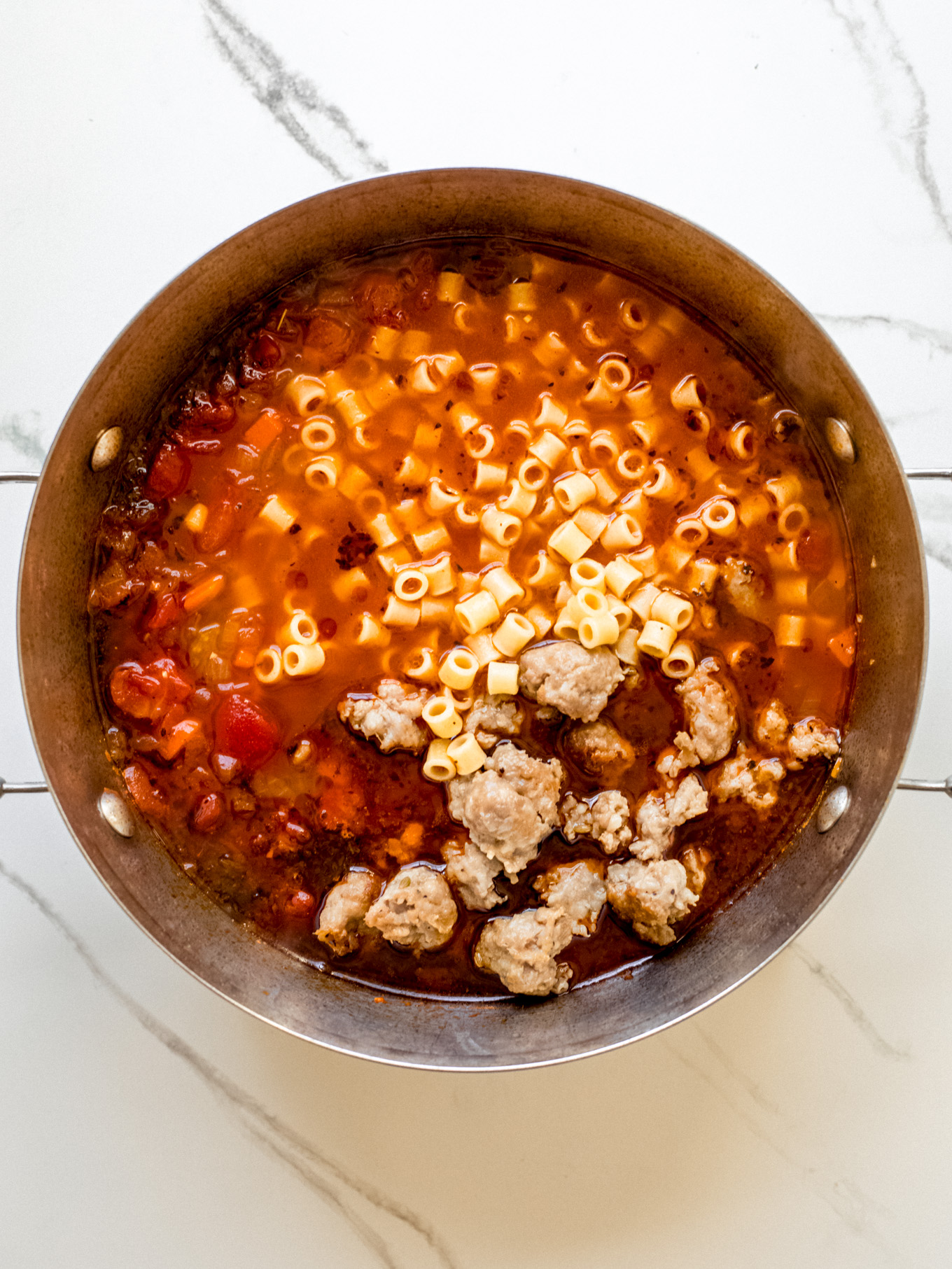 cooked sausage and pasta in a soup pot.