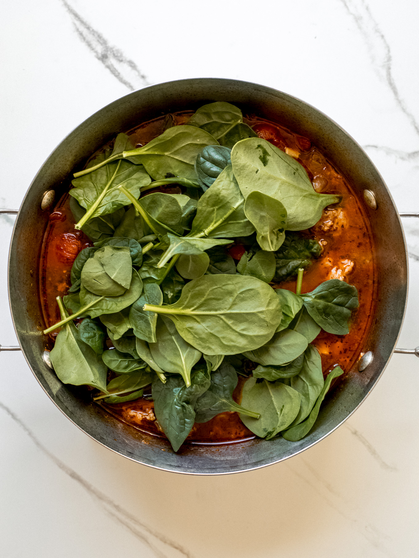 fresh spinach in a soup pot.