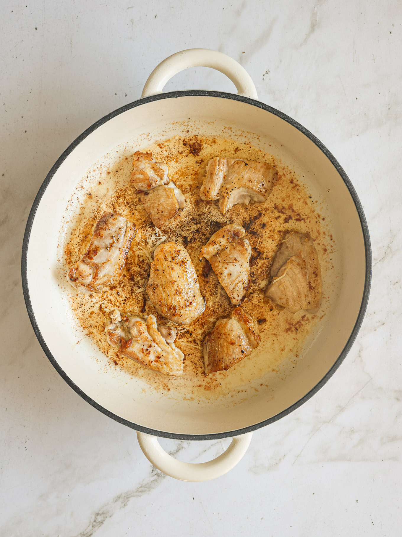 cooked chicken thighs in skillet.