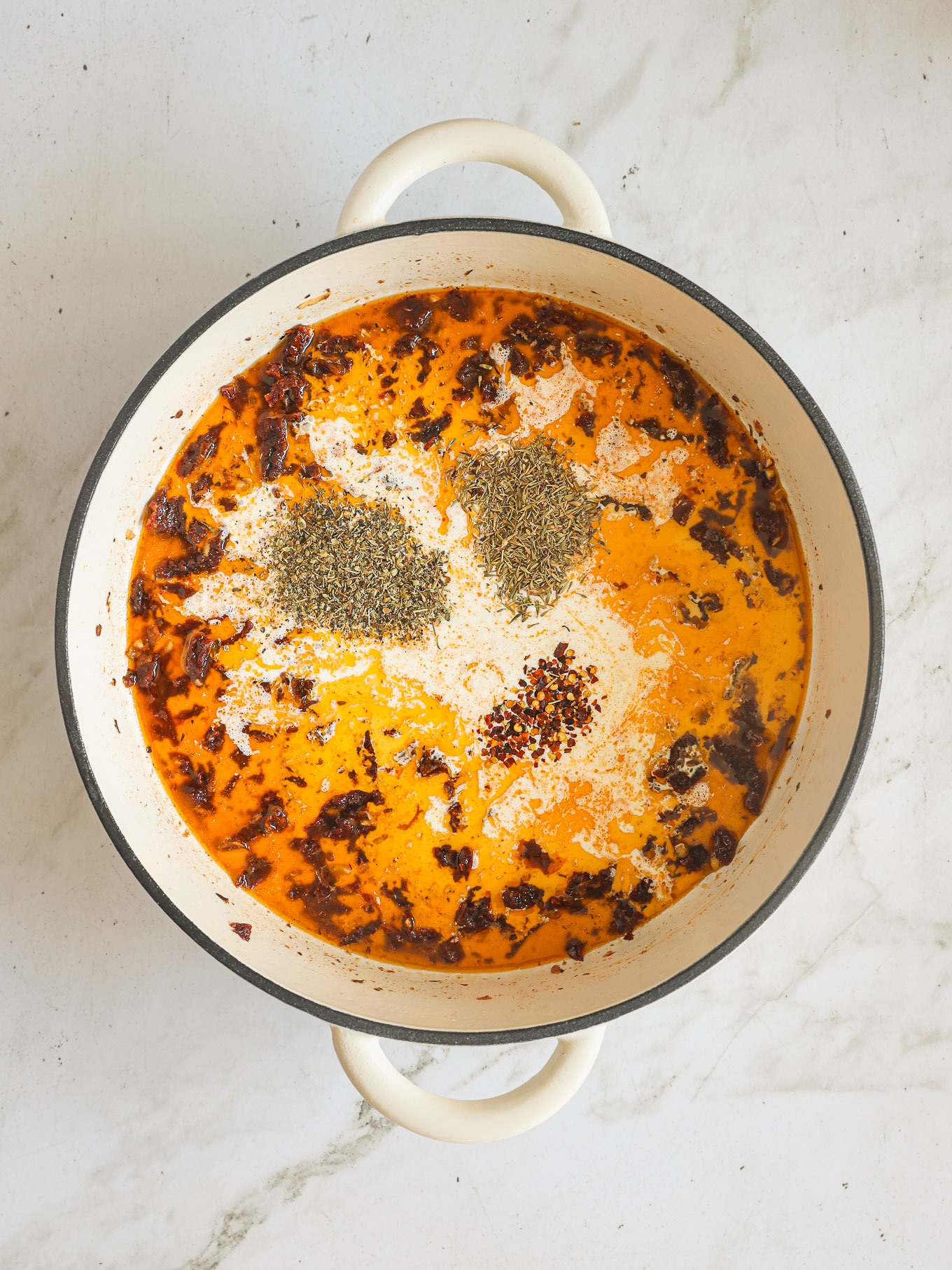 sun dried tomato cream sauce in pan with spices.