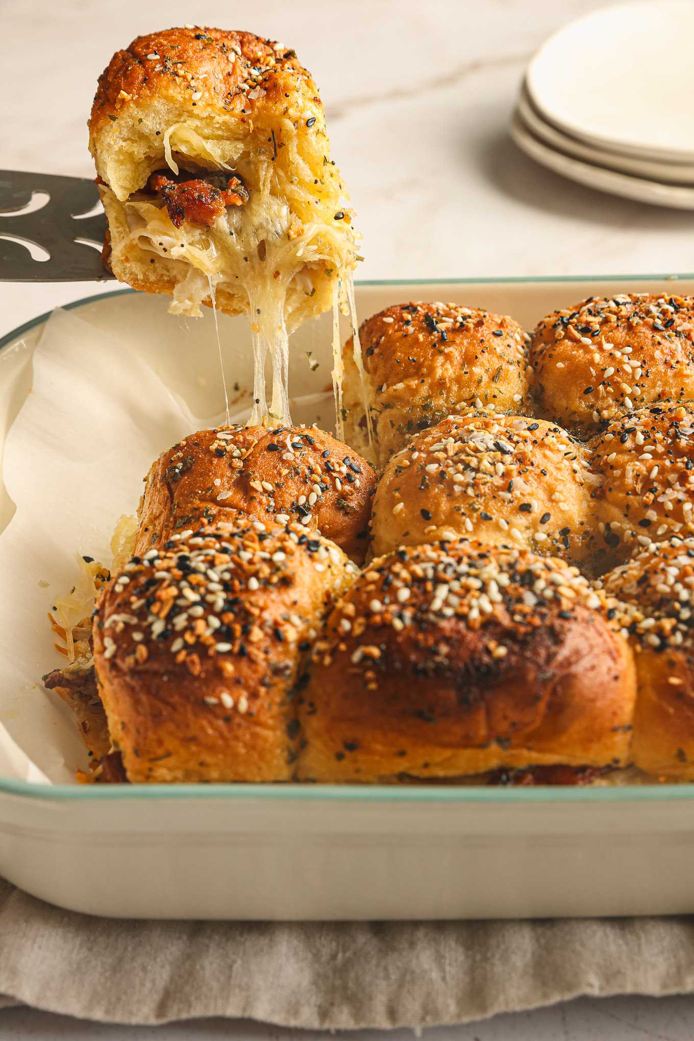 baked turkey and cheese sliders in a white dish.