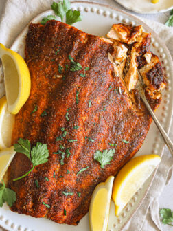 blackened salmon with lemon wedges.
