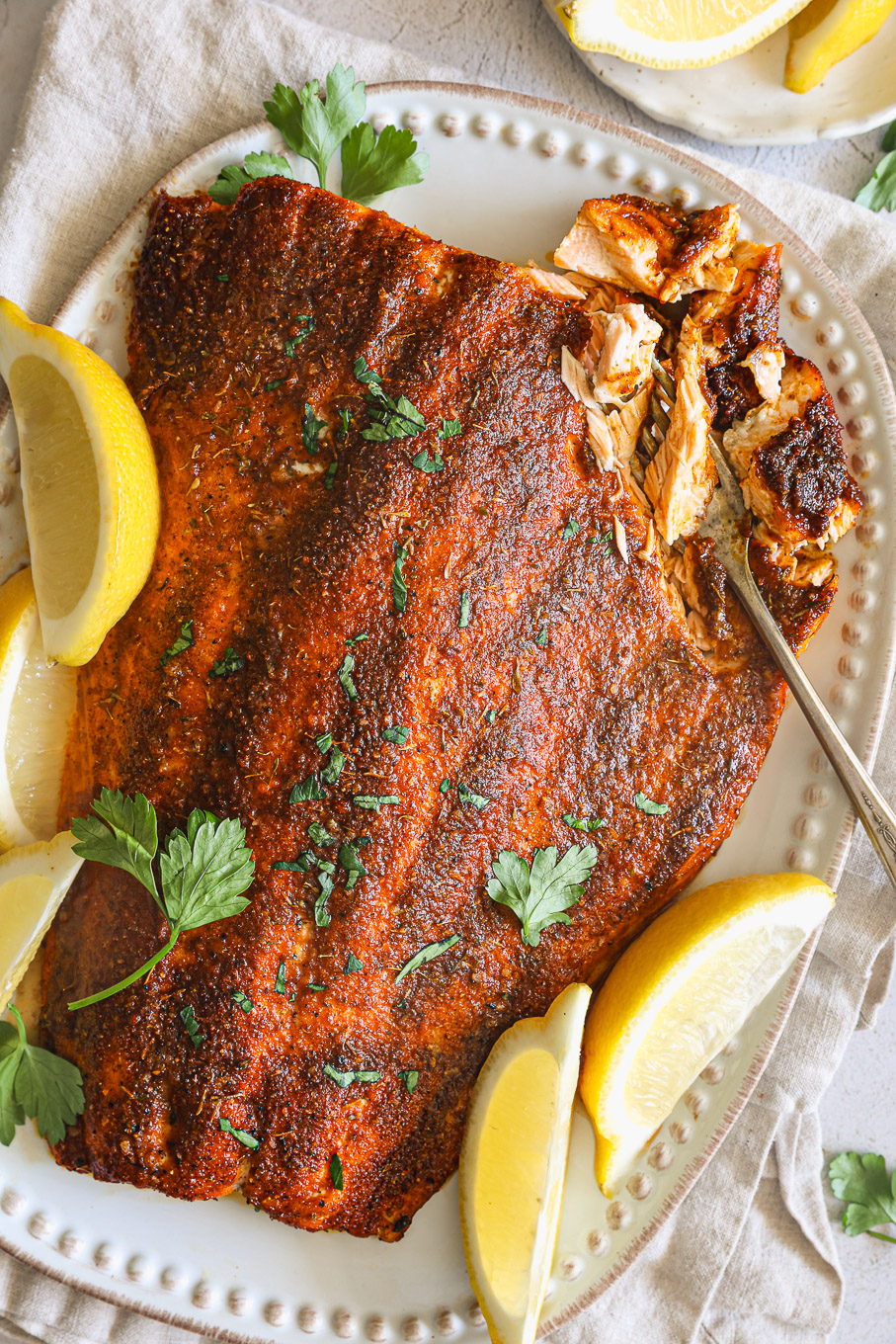 blackened salmon with lemon wedges.