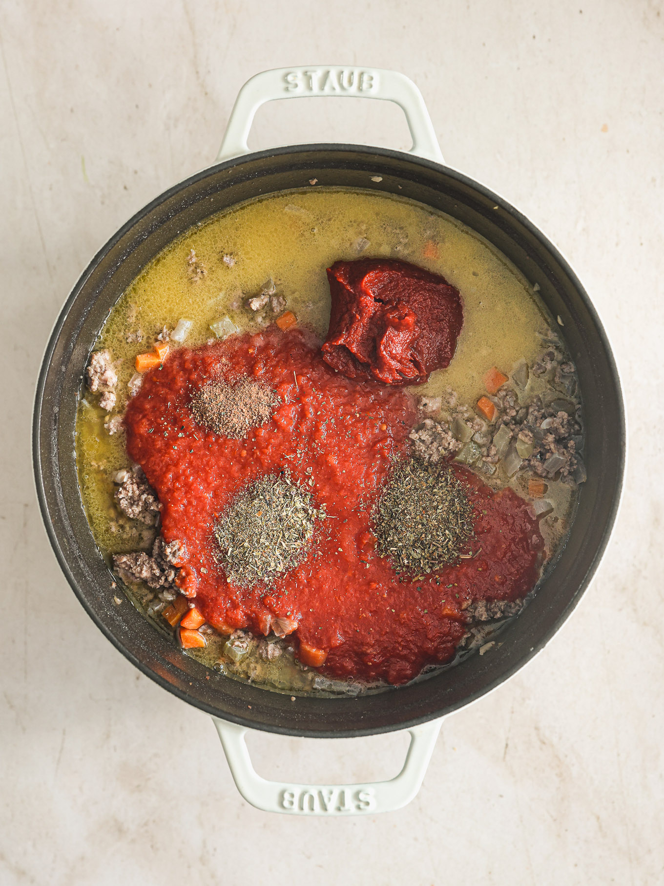 crushed tomatoes with spices in a dutch oven.