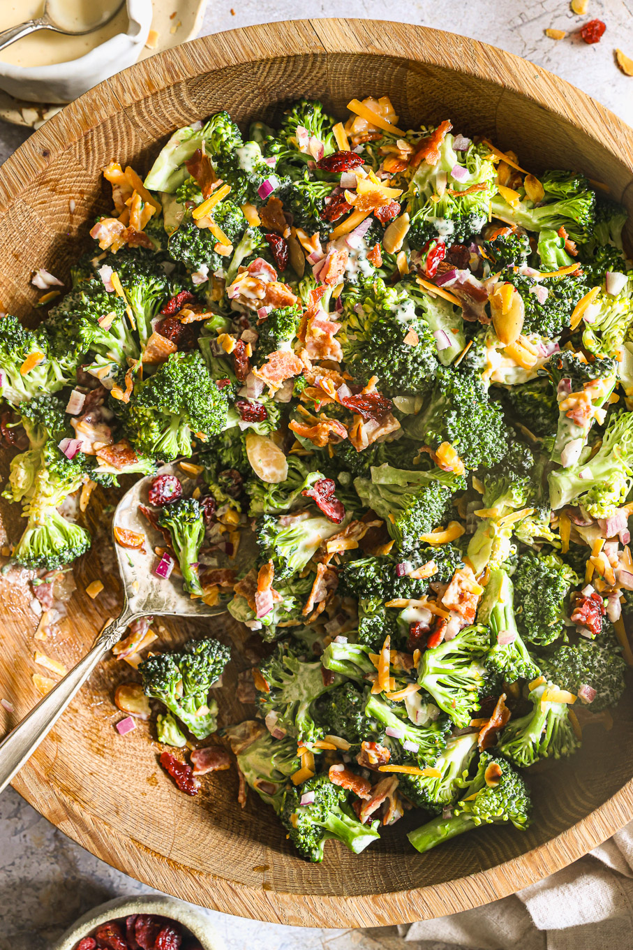 close up of broccoli salad with a serving spoon.