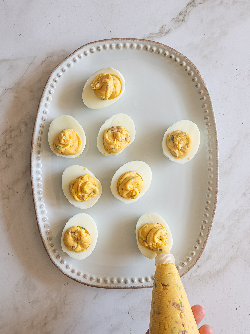 eggs white being piped with a filling.