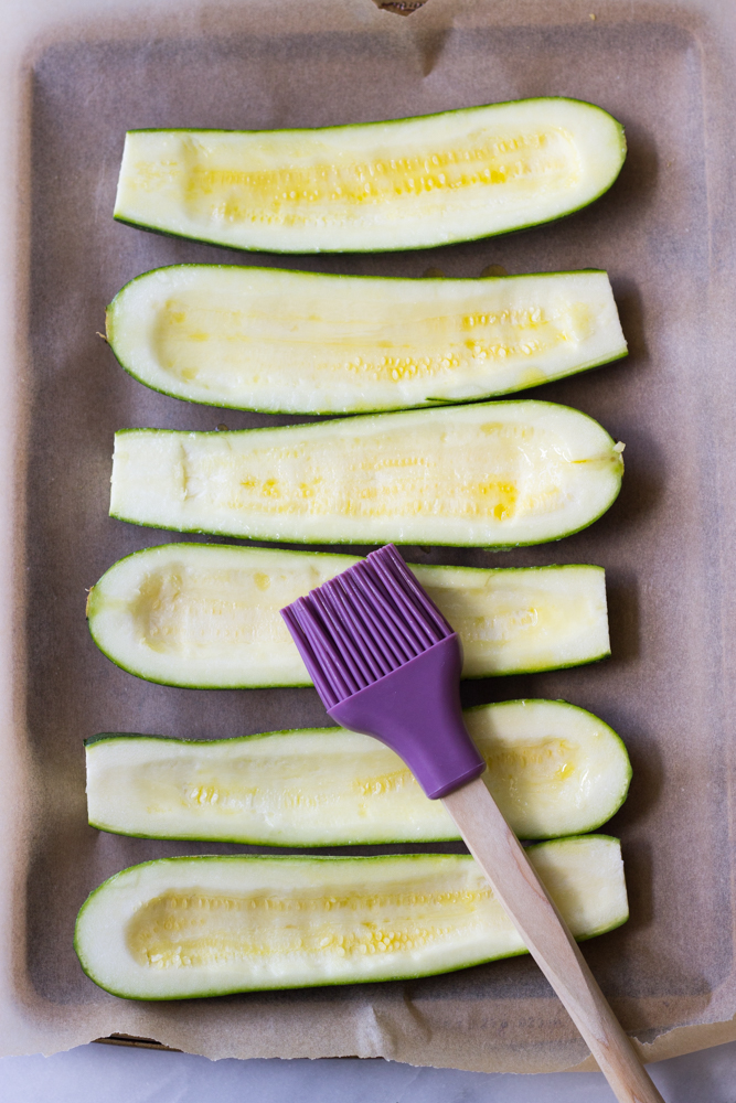 halved zucchini on a baking sheet.
