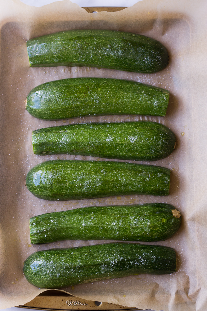 roasted zucchini halves on a baking sheet.