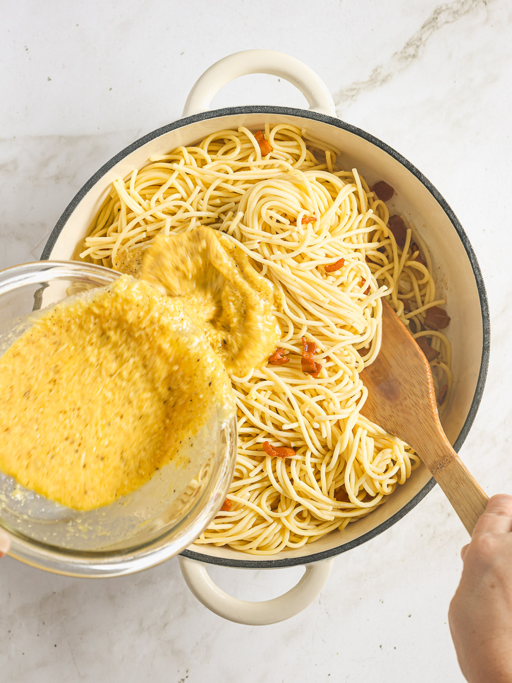 cooked spaghetti with egg mixture in a pan.