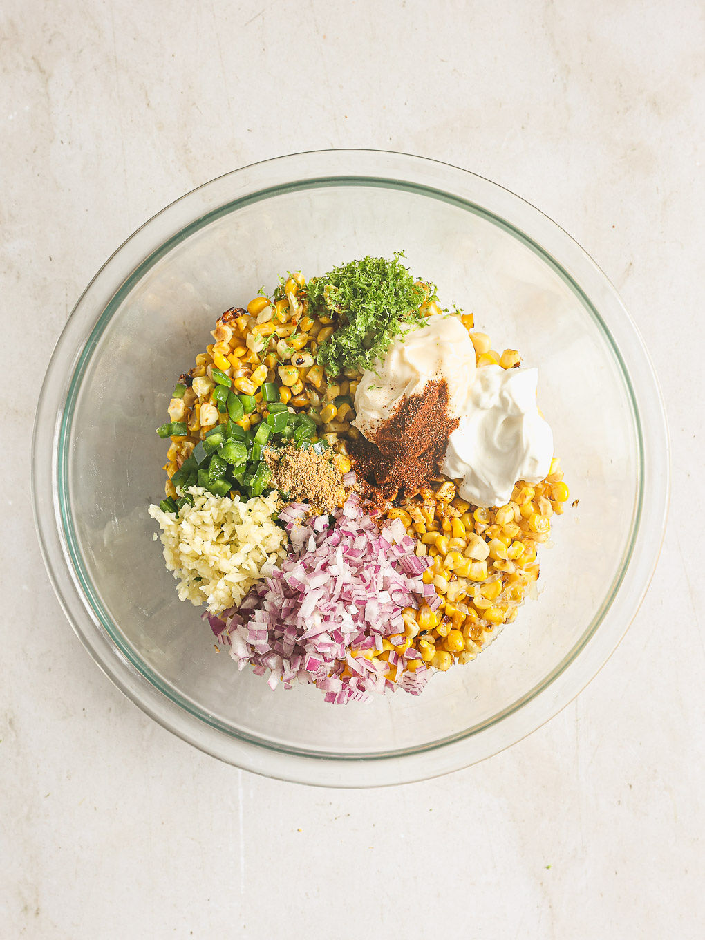 ingredients for corn salad in a glass bowl.
