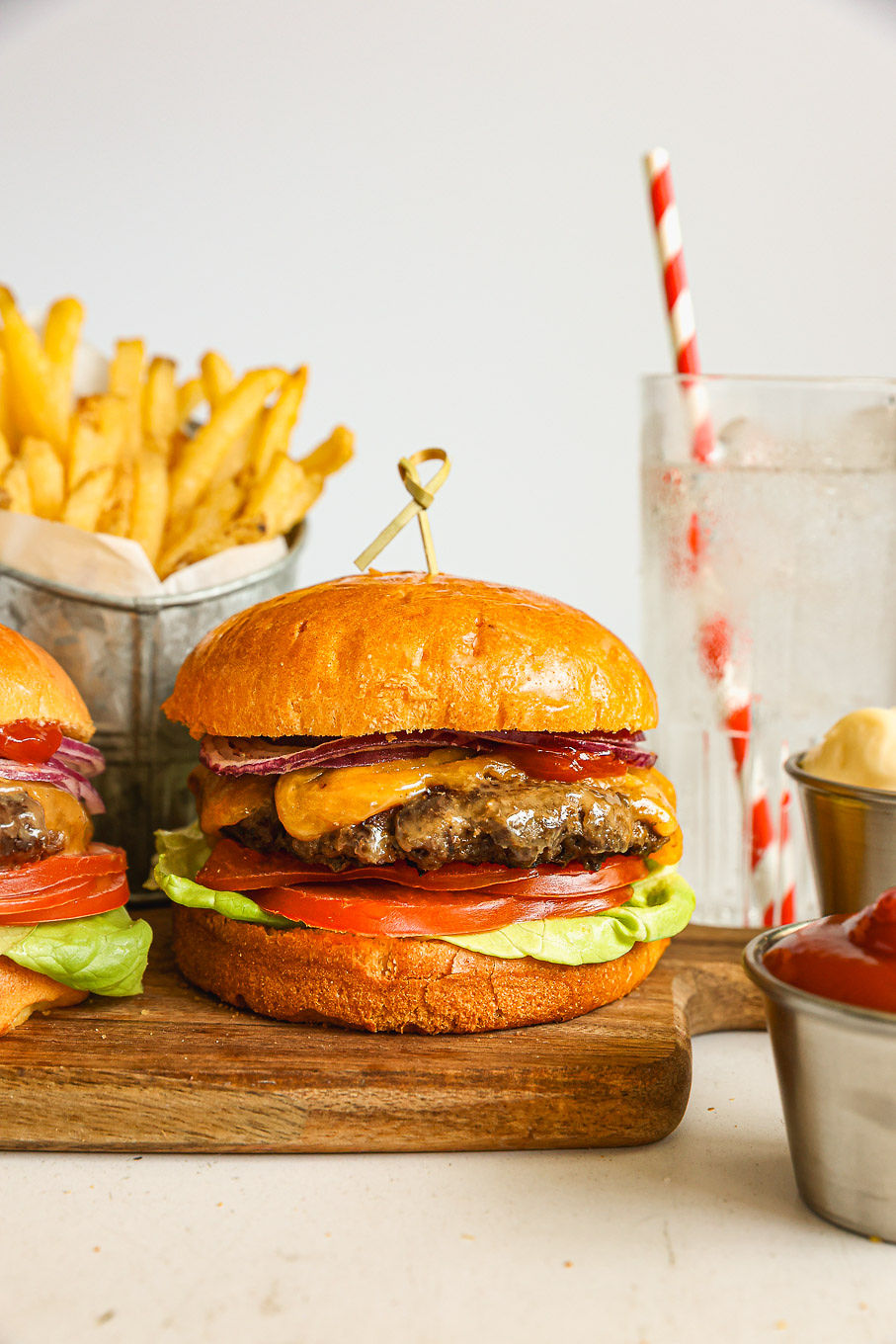 homemade beef burger on a board with toppings.