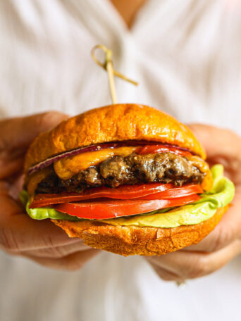 close up beef burger patty with toppings on a burger bun.