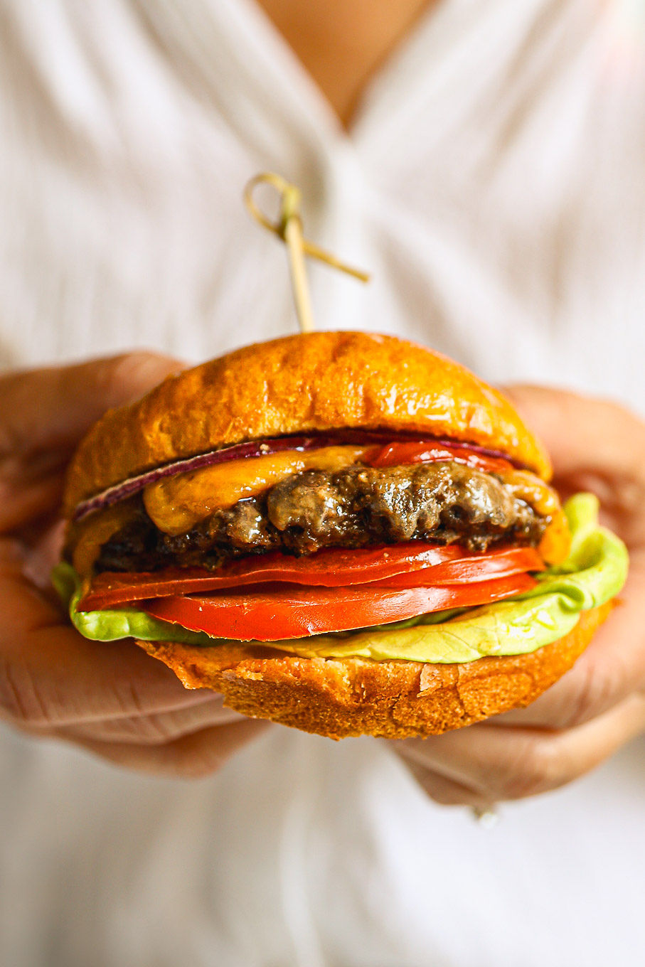 close up beef burger patty with toppings on a burger bun.