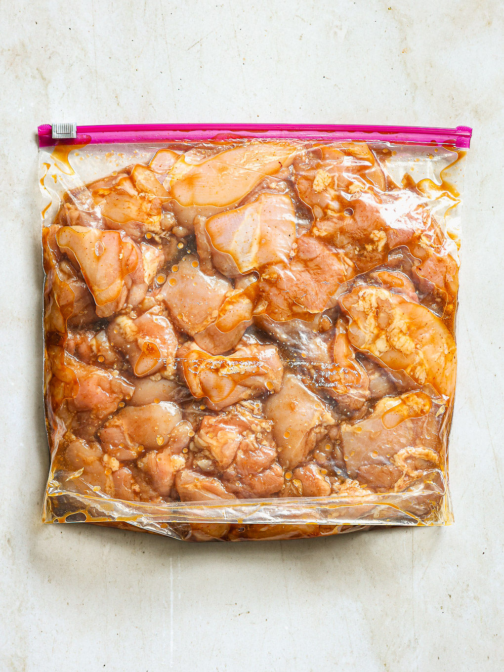 chicken pieces in ziploc bag with marinade.