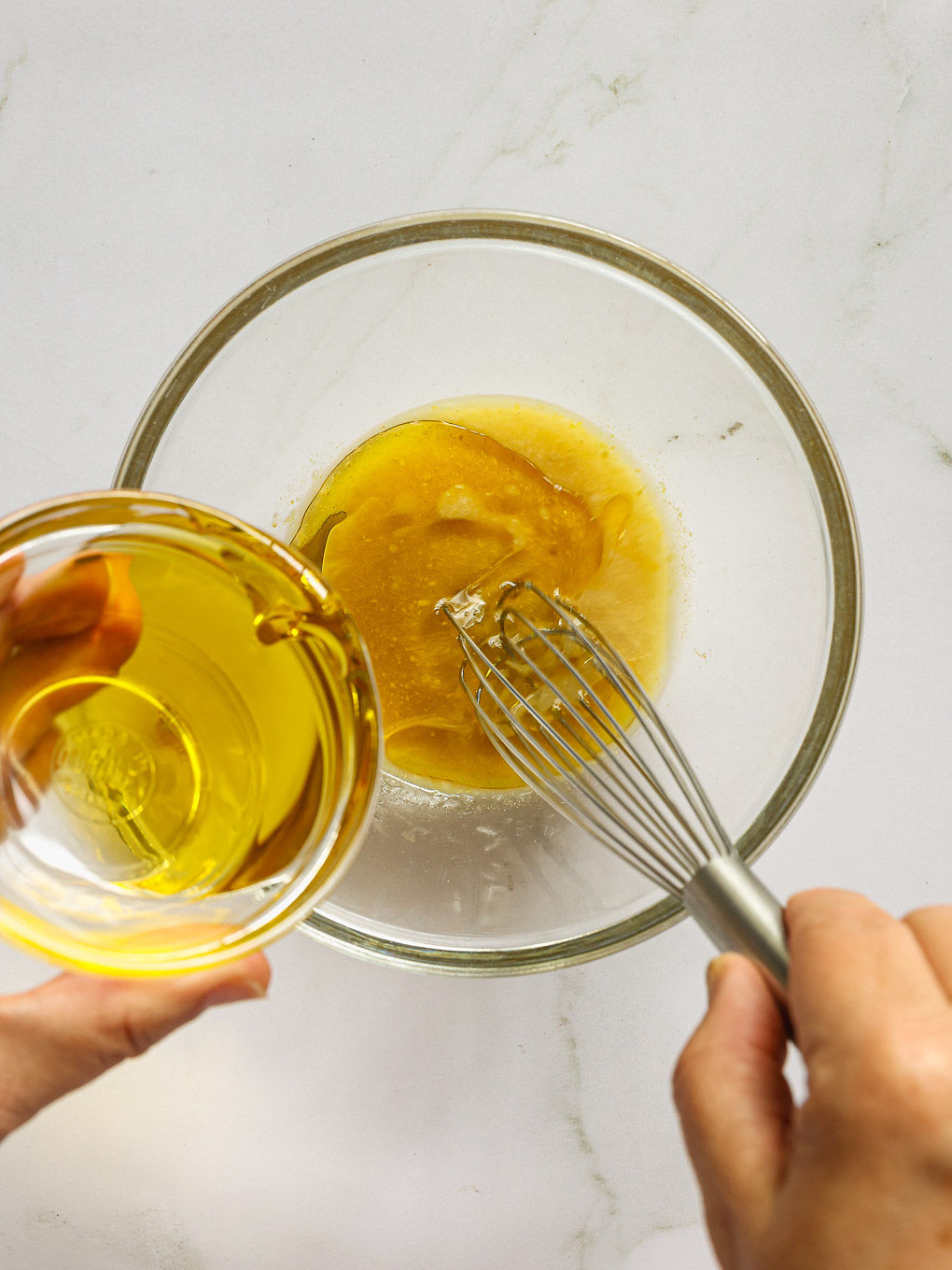 salad vinaigrette in a glass bowl with a whisk.