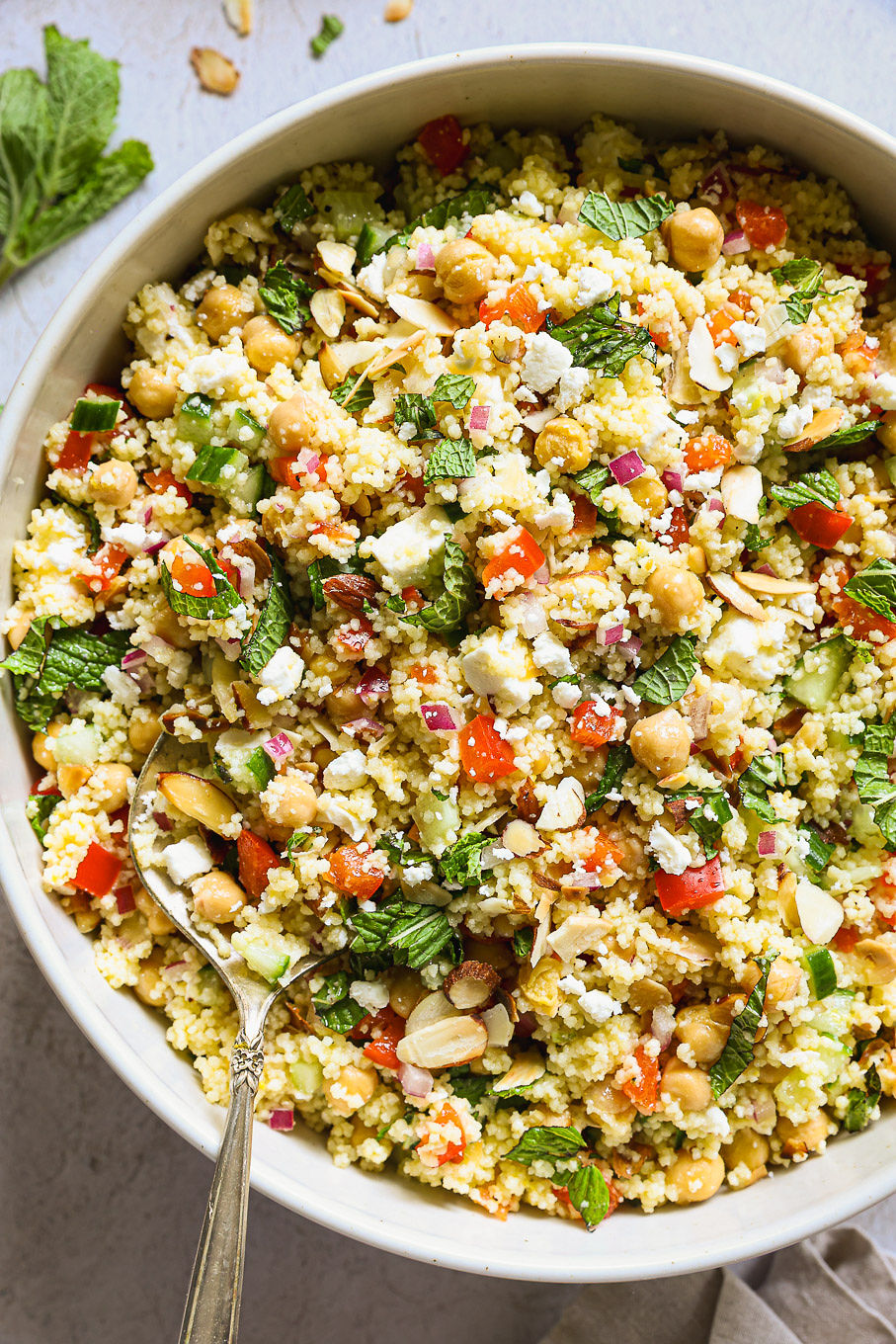 close up mediterranean couscous salad in a white bowl.
