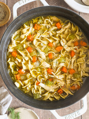 chicken noodle soup in a white pot.
