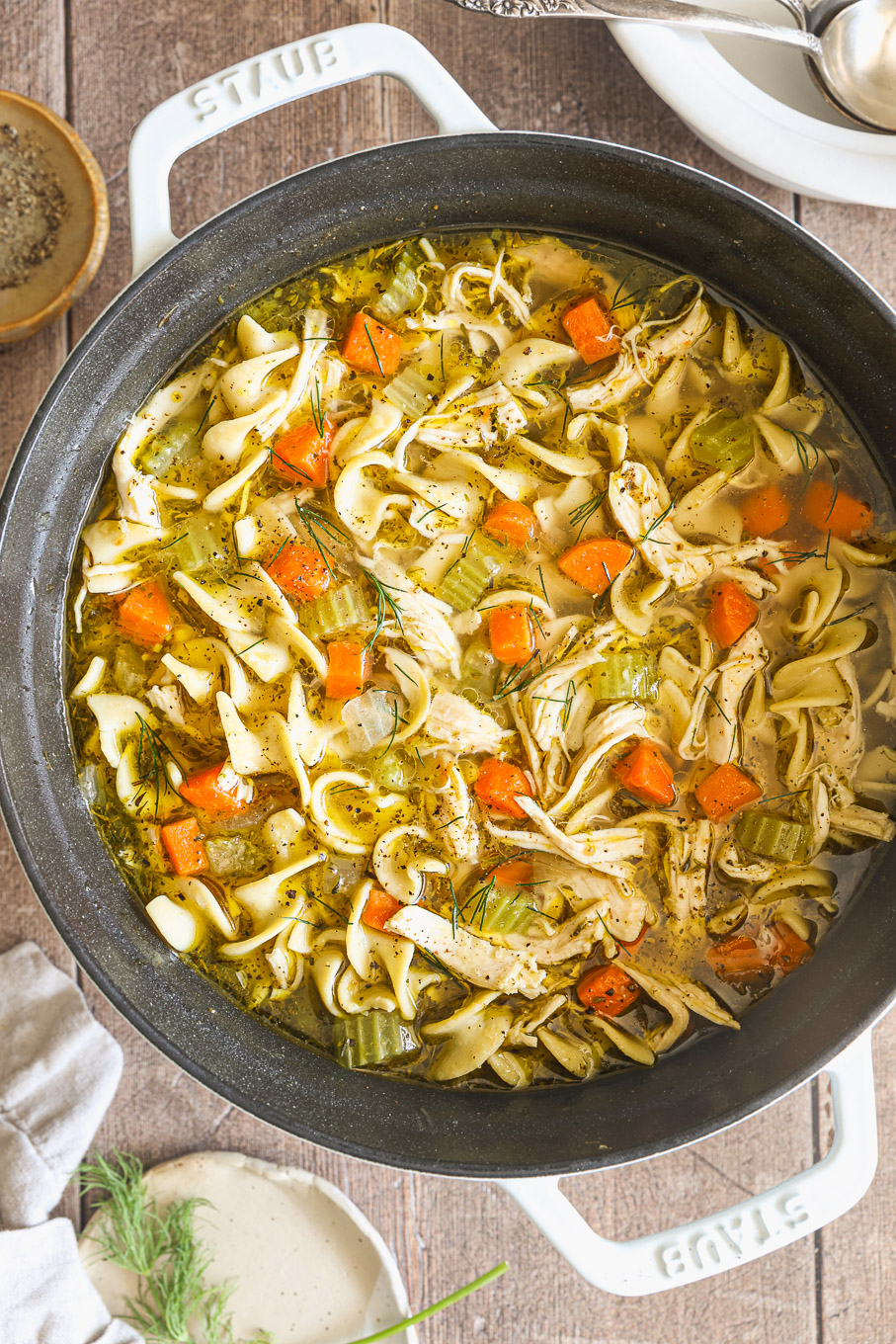 chicken noodle soup in a white pot.